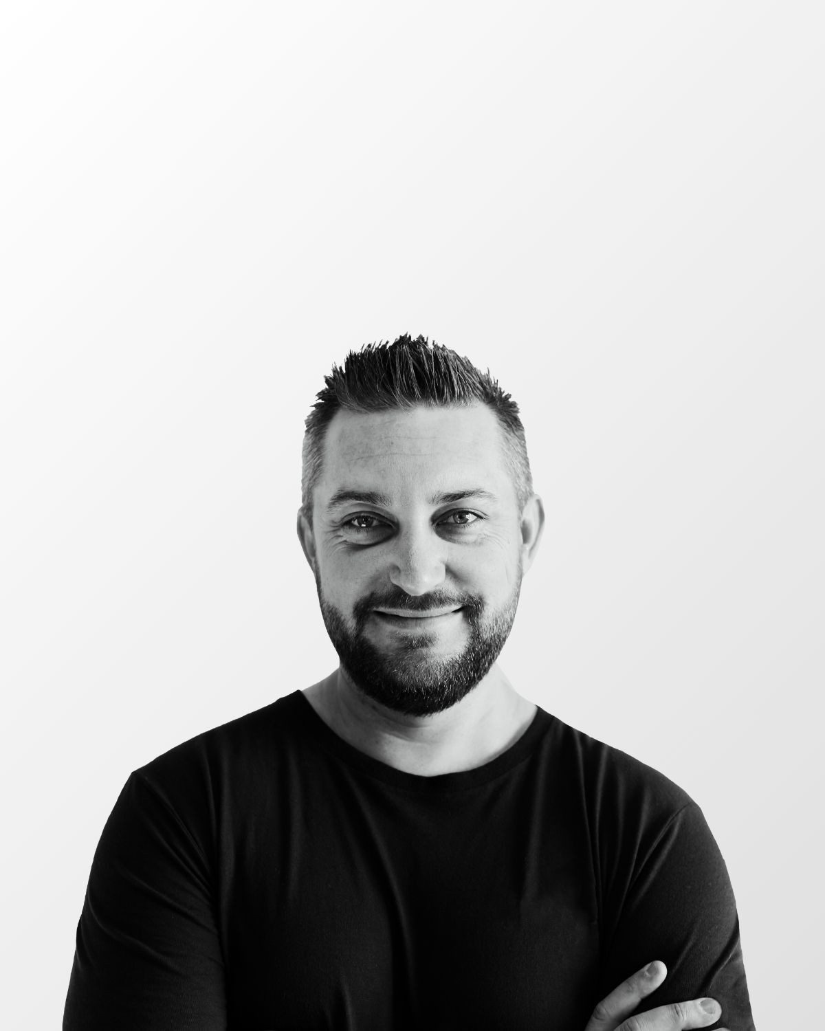 Black and white studio headshot of Joshua Brown with his arms crossed.