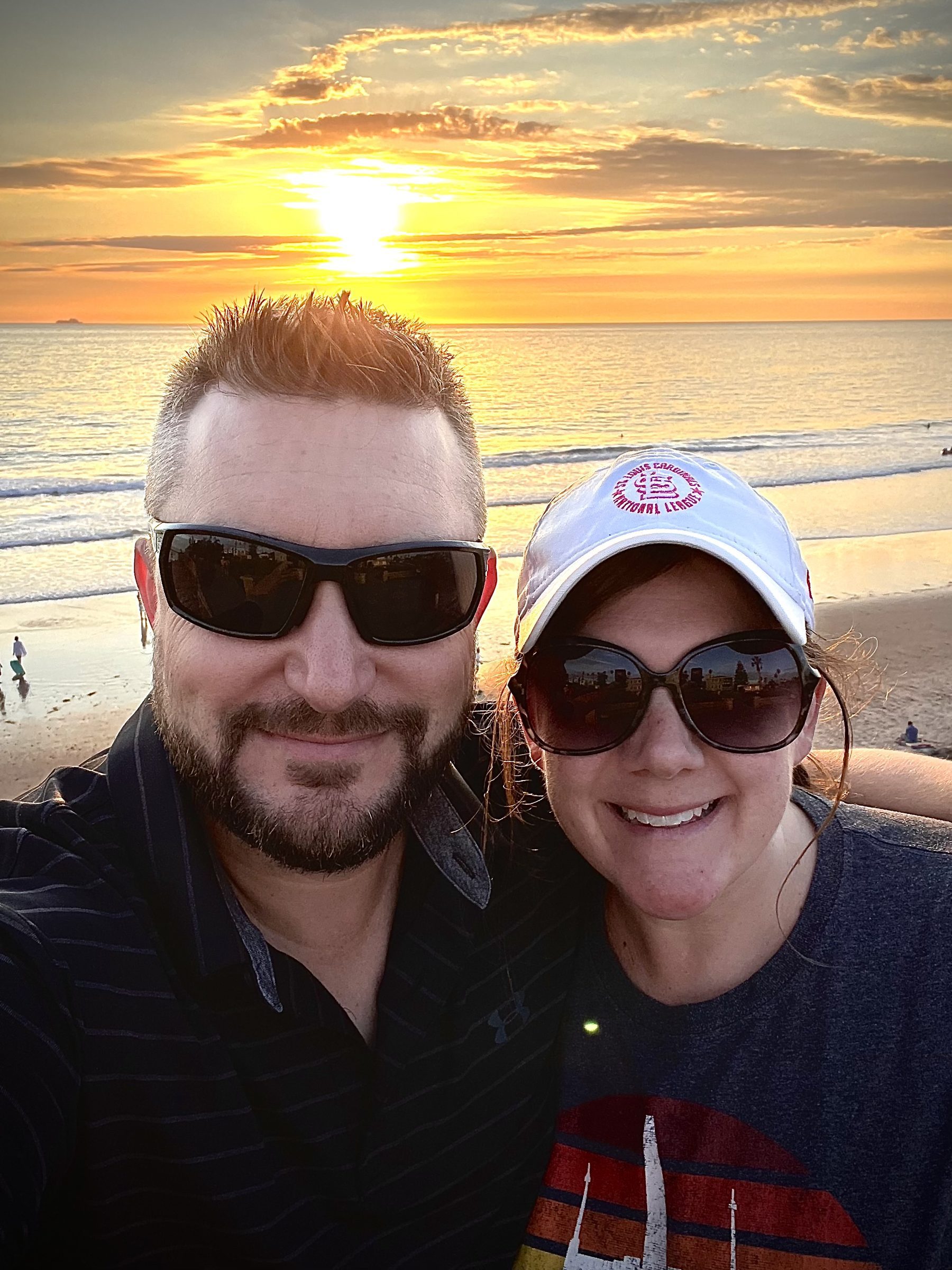 Joshua Brown and Laura taking a selfie on a beach at sunset.